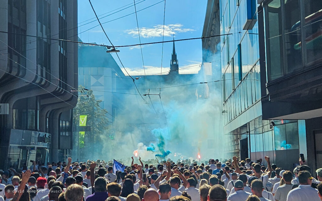 12. August 2023, Auswärtsmatch des FC Blau Weiß Linz bei den Rosaroten auf der Gugl. Stimmung in der Rudigerstraße mit vernebeltem Blick auf den Dom.